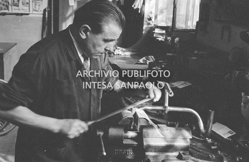 Il meccanico Giuseppe De Grandi, detto Pinella, prepara la bicicletta di Roger Rivière in vista del record dell'ora che il ciclista francese si sarebbe aggiudicato di lì a tre giorni