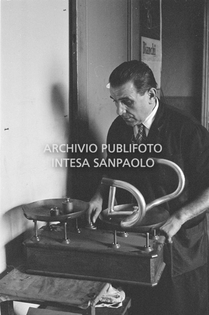 Il meccanico Giuseppe De Grandi, detto Pinella, pesa il manubrio di una bicicletta durante la preparazione di quella per Roger Rivière con la quale,  di lì a tre giorni, il ciclista francese si sarebbe aggiudicato il record dell'ora