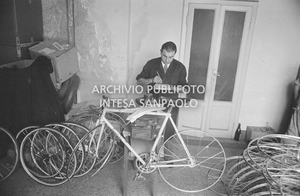 Il meccanico Giuseppe De Grandi, detto Pinella, prende appunti durante la preparazione della bicicletta di Roger Rivière in vista del record dell'ora che il ciclista francese si sarebbe aggiudicato di lì a tre giorni