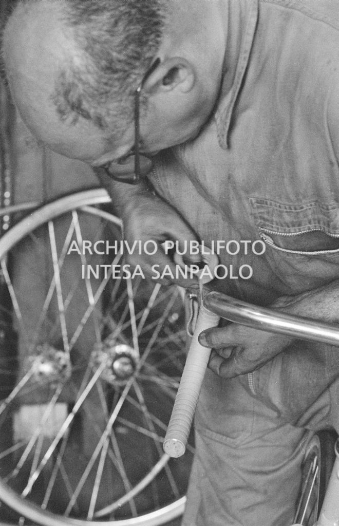 L'assistente del meccanico Giuseppe De Grandi, detto Pinella, aiuta a preparare la bicicletta di Roger Rivière in vista del record dell'ora che il ciclista francese si sarebbe aggiudicato di lì a tre giorni