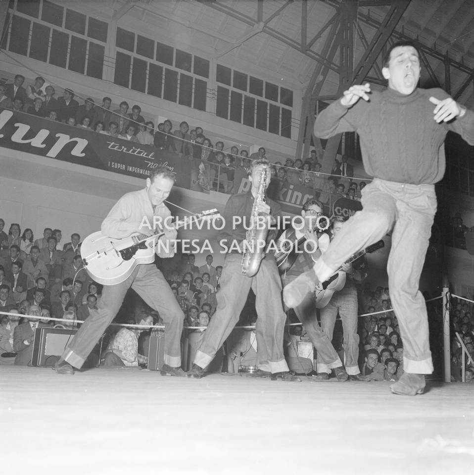 Adriano Celentano canta e balla accompagnato dai Rock Boys al Palazzo del ghiaccio di Milano, in occasione del Festival del Rock and Roll