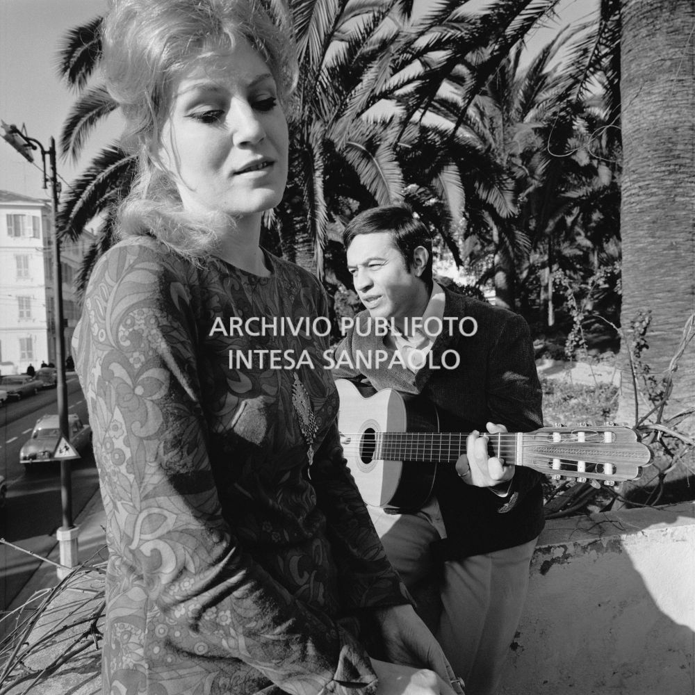 Anna German e Fred Bongusto, con la chitarra, seduti su un muretto a Sanremo nei giorni del Festival