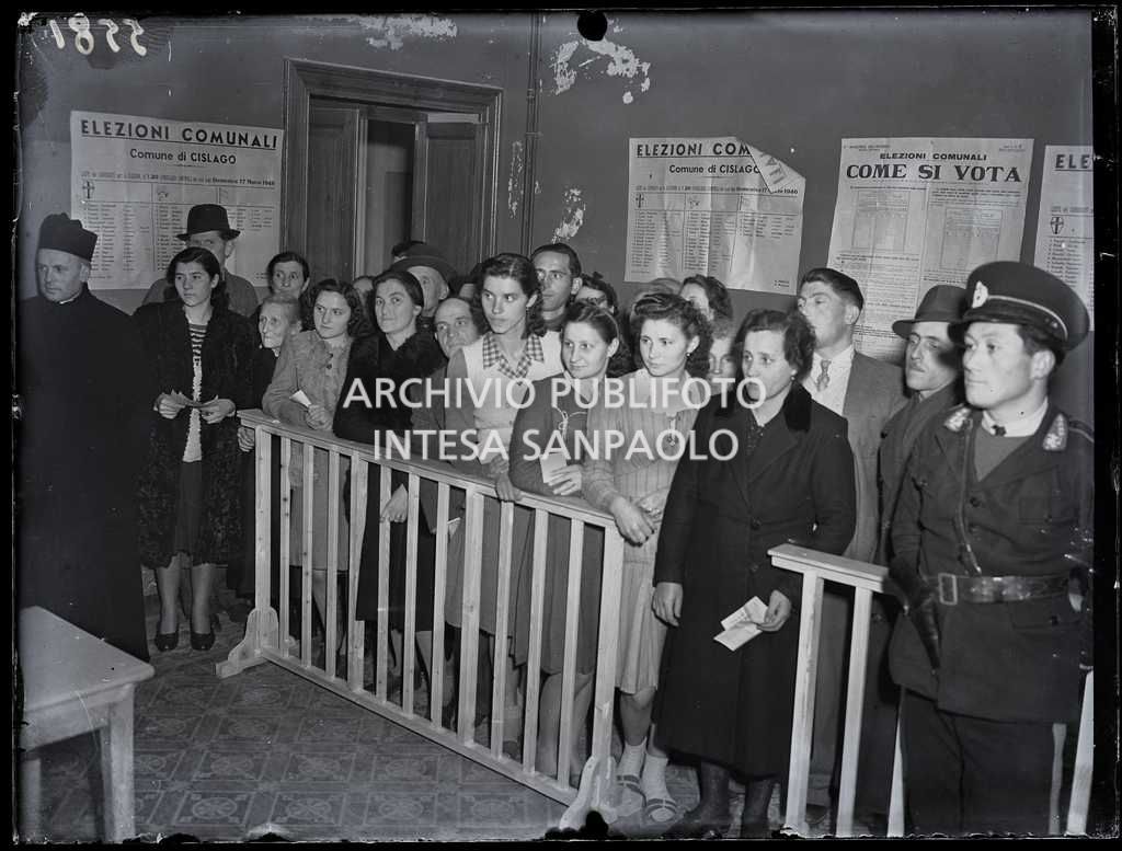 Donne e uomini in coda al seggio in occasione delle elezioni comunali a Cislago, le prime elezioni con suffragio universale in Italia