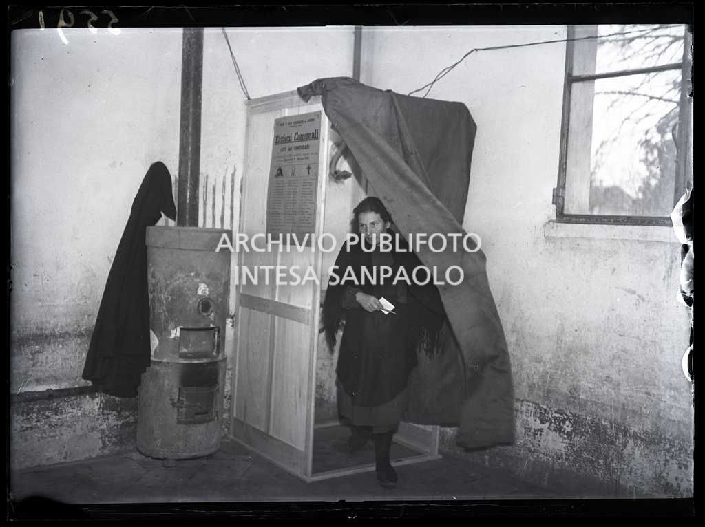 Una donna esce dalla cabina dopo aver votato alle elezioni comunali a San Colombano al Lambro, le prime elezioni con suffragio universale in Italia