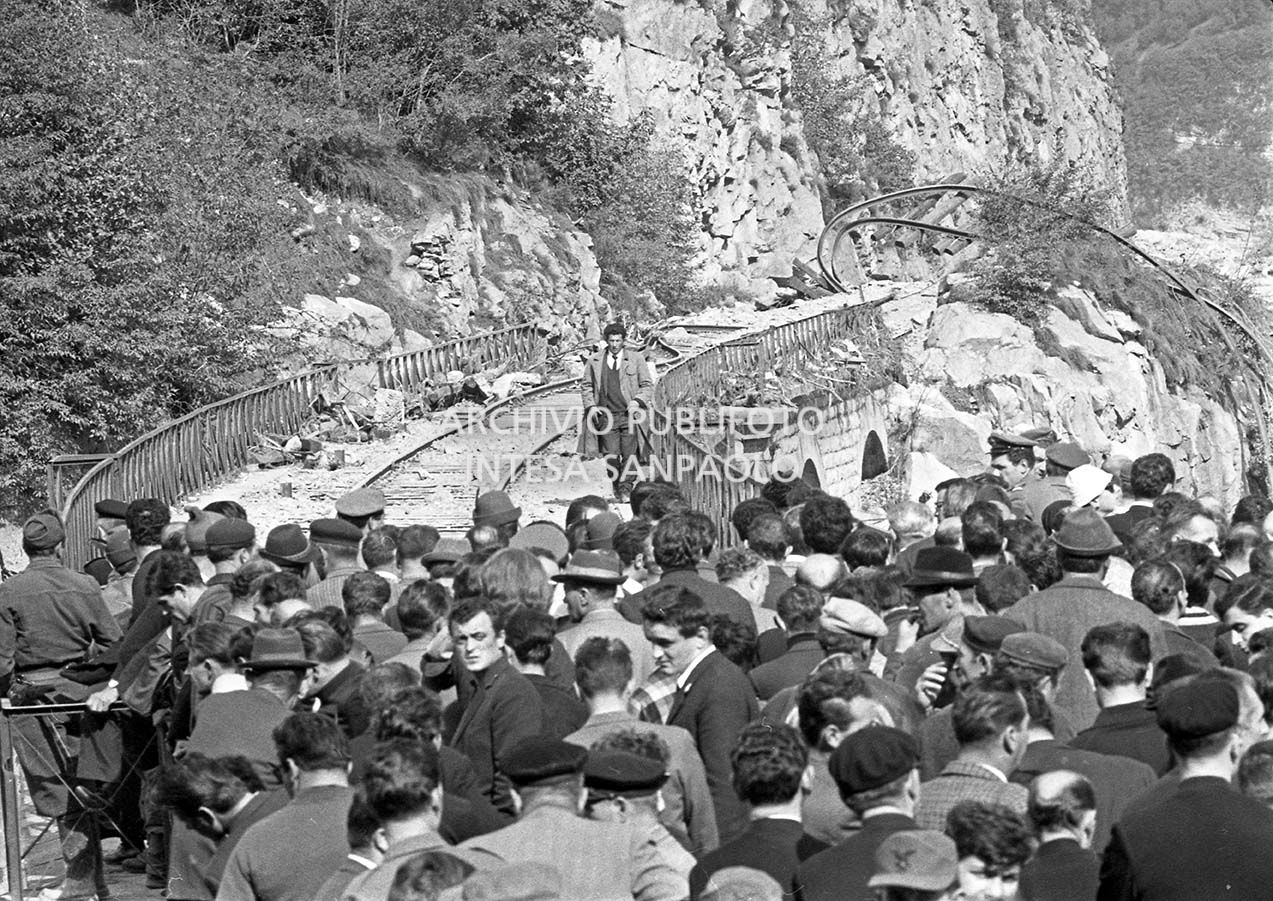 Disastro del Vajont: una piccola folla a ridosso di un ponte ferroviario con i binari divelti