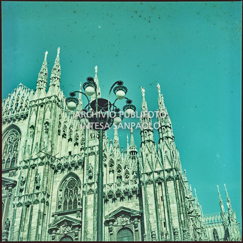 Uno scorcio della facciata del Duomo di Milano e delle guglie. In primo piano un lampione