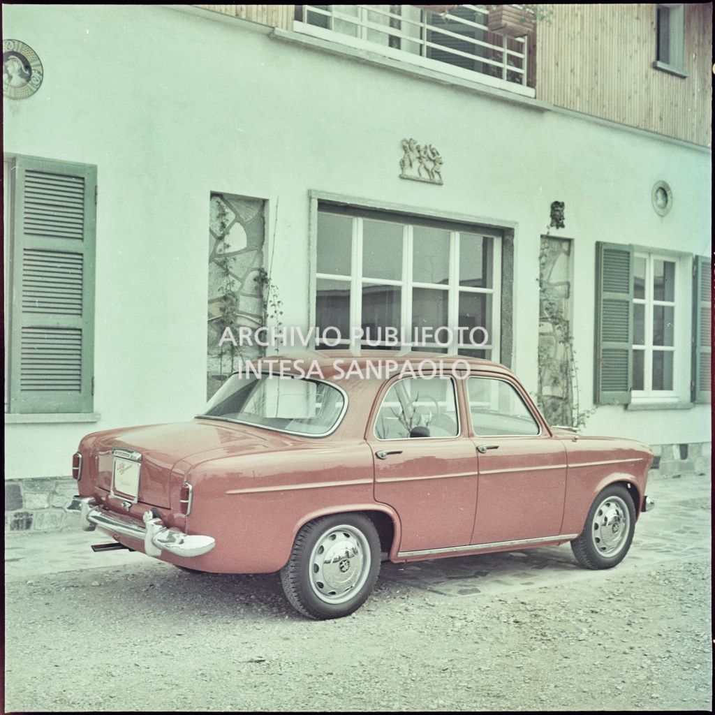 Lato destro e coda di una Alfa Romeo Giulietta berlina di colore rosso davanti ad una abitazione