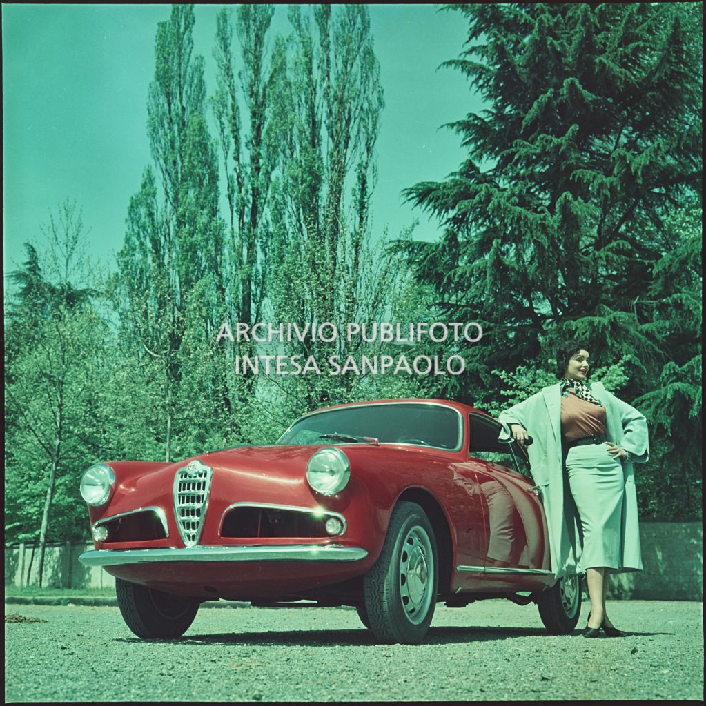 Alfa Romeo rossa 1900 con modella in un giardino