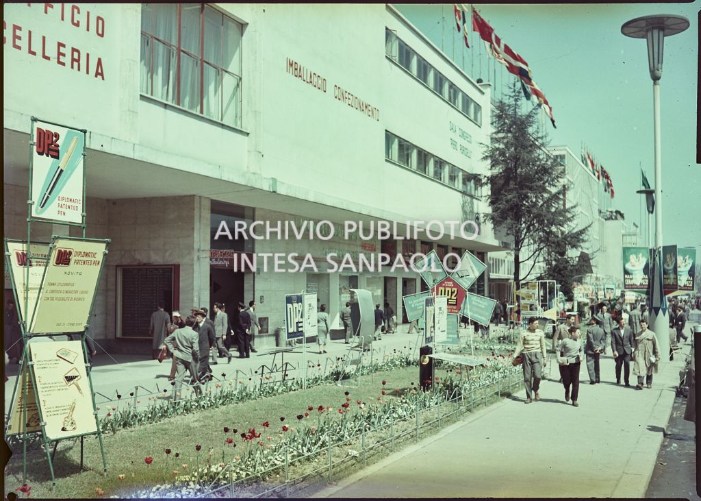 Esterno del padiglione dedicato alle macchine, forniture per ufficio e cancelleria alla Fiera Campionaria di Milano del 1955; alcuni visitatori passeggiano lungo il viale dell'Industria