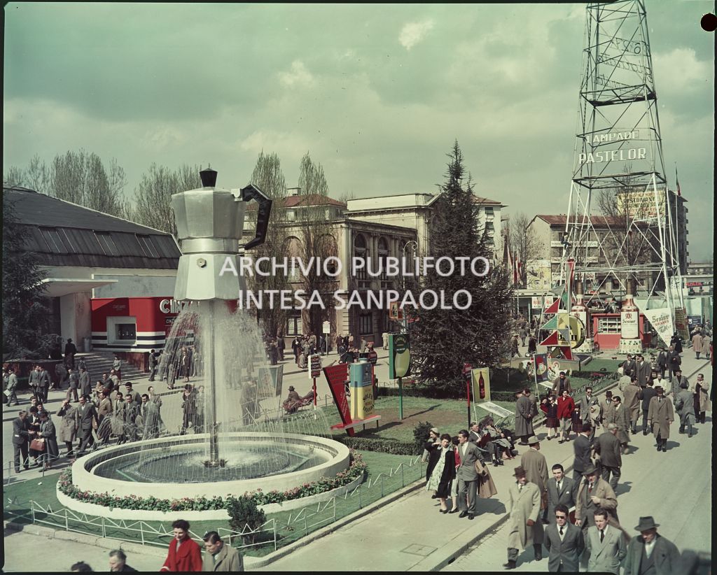 Vista su viale dell'Industria con visitatori. In primo piano l'istallazione pubblicitaria della Bialetti realizzata da una fontana a forma di caffettiera