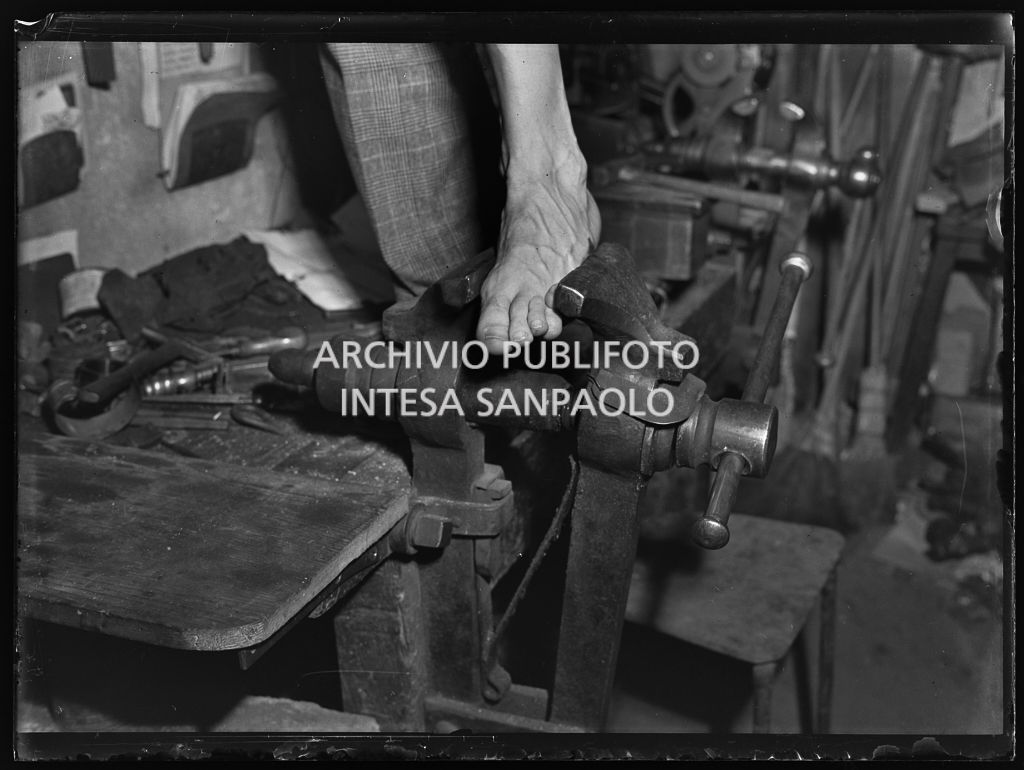 Un piede maschile stretto in una morsa da falegname