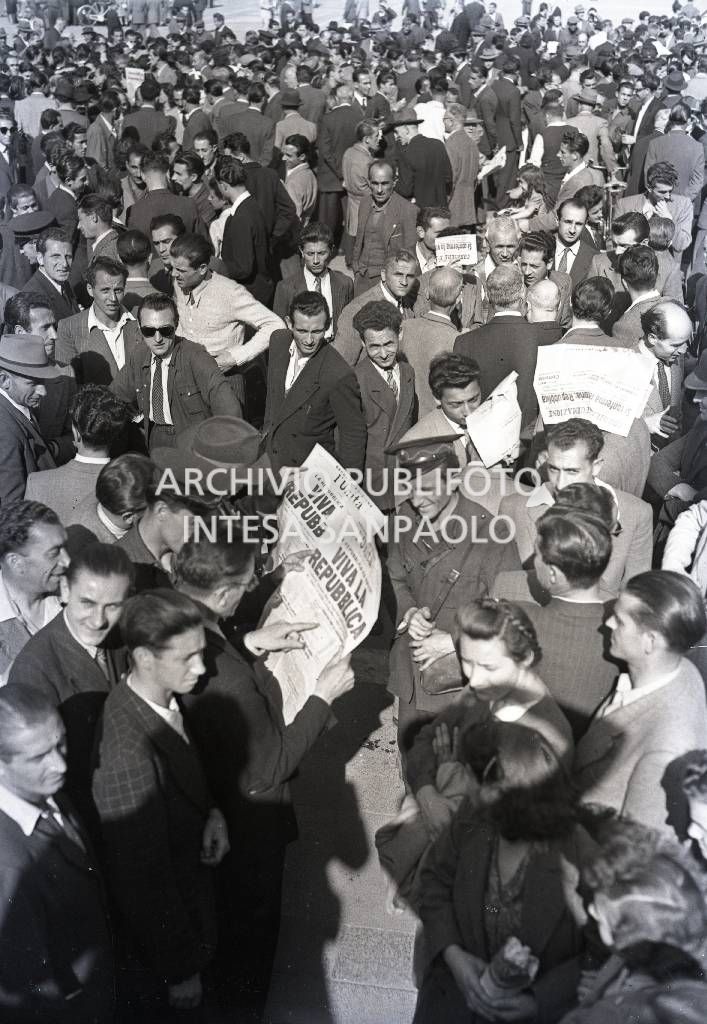 Folla di persone, alcune con i quotidiani in mano che titolano la vittoria della Repubblica all'indomani del Referendum popolare
