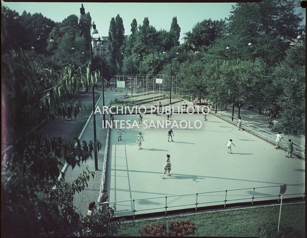Ripresa dall'alto di un parco con una pista per il pattinaggio a rotelle e del campetti da basket con bambini che giocano