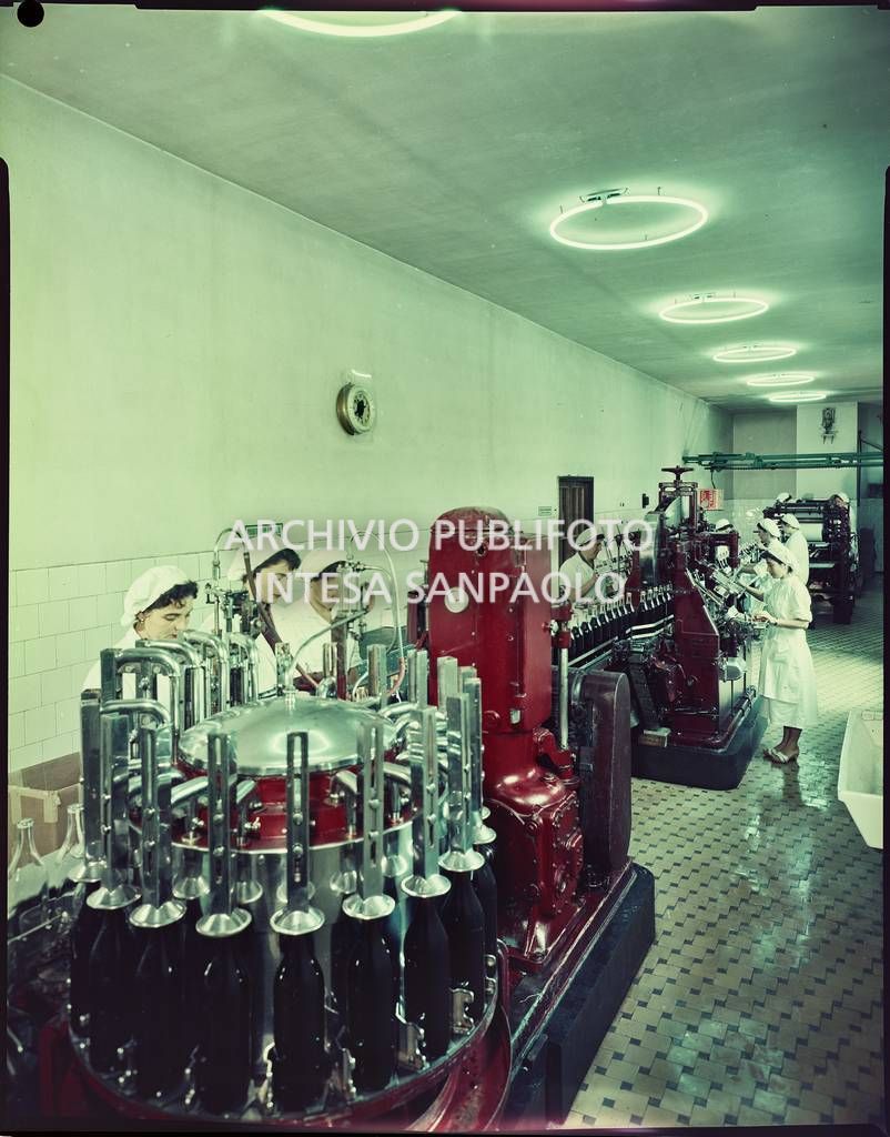 Operaie al lavoro nel reparto di imbottigliamento dell'amaro Cynar nello stabilimento della Pezziol