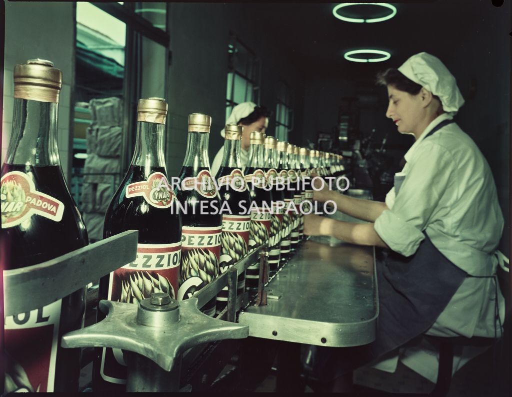 Operaie al lavoro nel reparto di etichettatura dell'amaro Cynar nello stabilimento della Pezziol