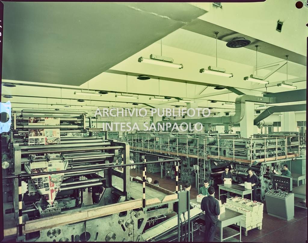 Vista del reparto di piegatura e fascicolatura nello stabilimento Mondadori a Verona con operai al lavoro sulla rivista "Bolero Film"