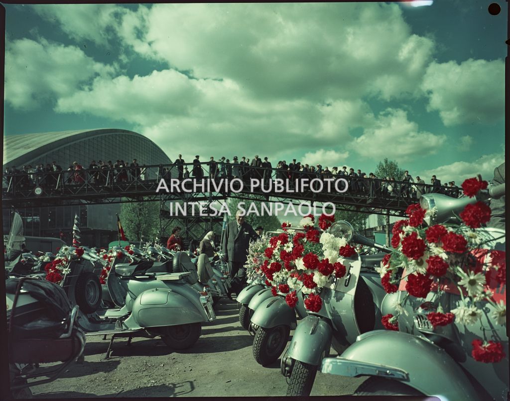 Motociclette Vespa, adornate con fiori, parcheggiate in una piazza in occasione dell'EuroVespa di Parigi del 1959