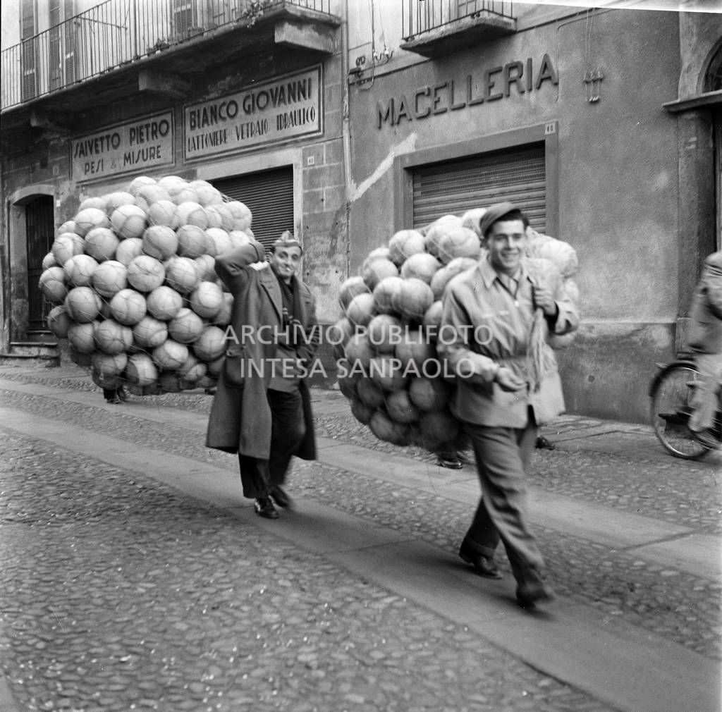 Due uomini trasportano delle reti piene di palloni al Carnevale di Ivrea<br>120172