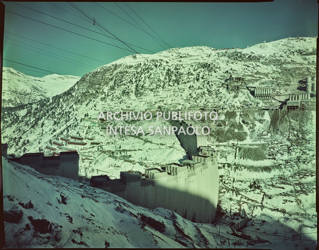 Vista di una diga della Edison in costruzione sulle montagne innevate