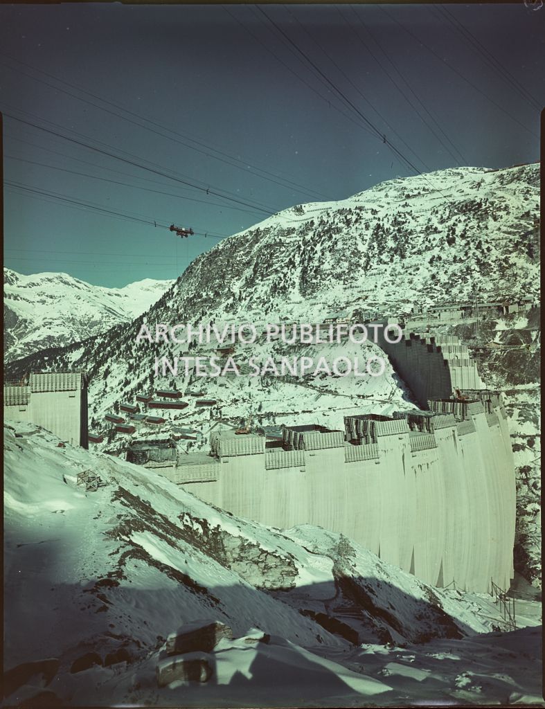 Vista di una diga della Edison in costruzione sulle montagne innevate