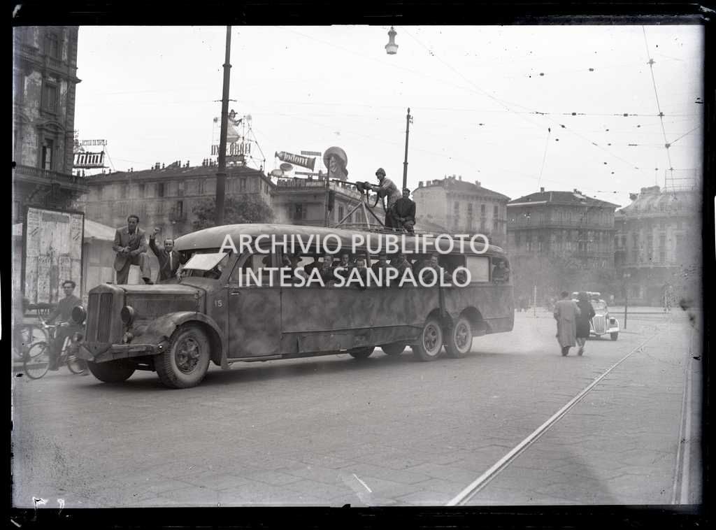 Un pullman camouflage in una via di Milano: all'interno e sul tetto uomini del C.V.L. (Corpo Volontari della Libertà) armati