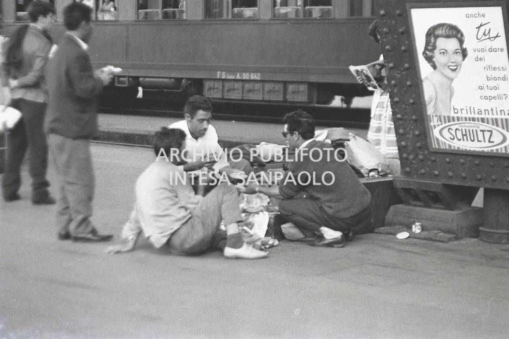 Immigrati dal Sud Italia mangiano sulla banchina alla Stazione Centrale di Milano