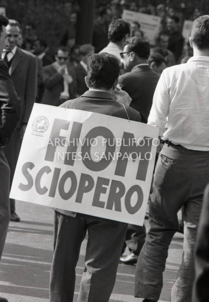 Lavoratori metalmeccanici in occasione dello sciopero generale; un uomo porta appeso un il cartello con la scritta: Sciopero FIOM<br>707264/19