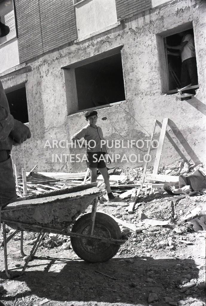 Ragazzino ritratto in un cantiere edile: in primo piano una carriola<br>721238/1