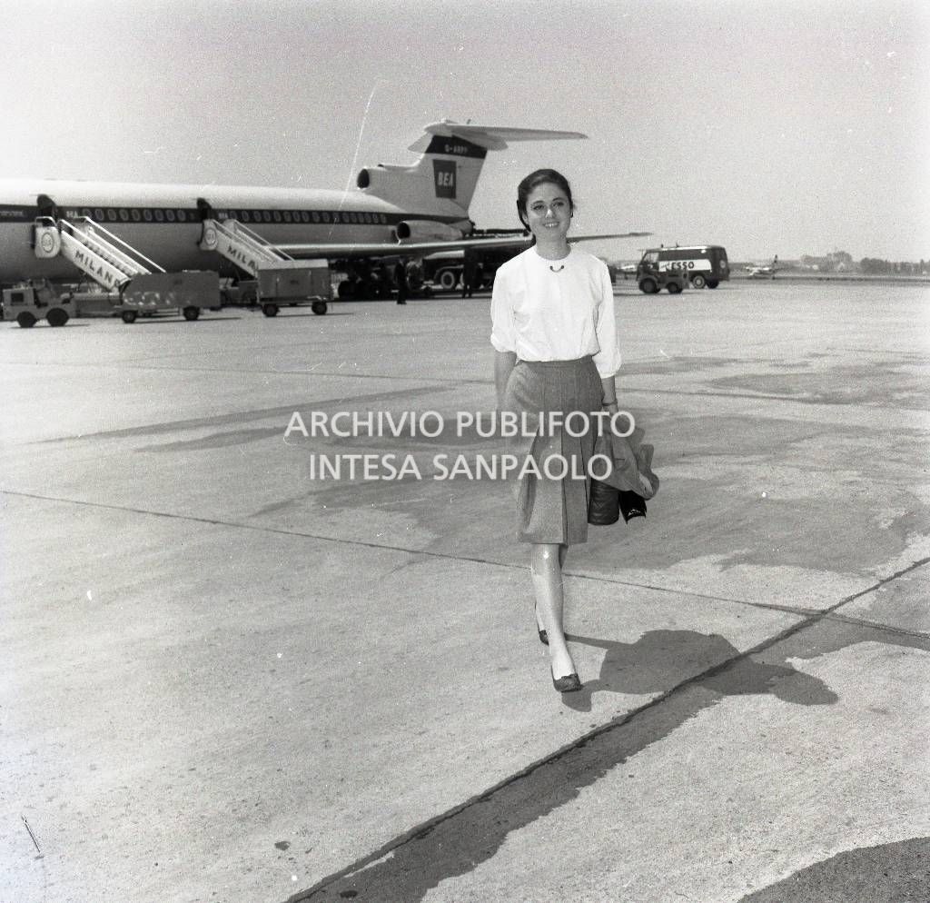 Gigliola Cinquetti al suo arrivo all'aeroporto di Milano Linate;  alle sue spalle un aeroplano in pista<br>722906/7