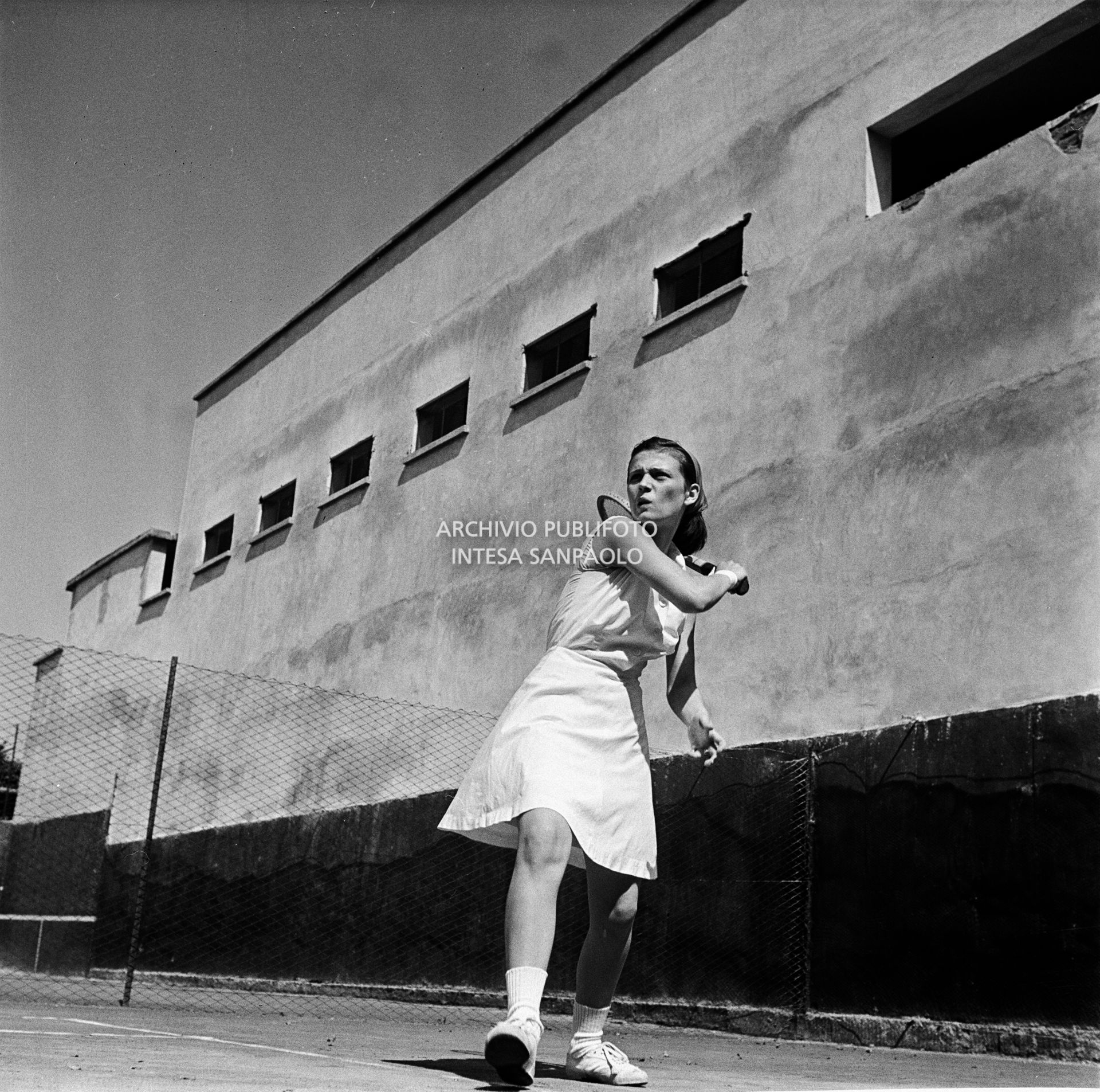 Una ragazza gioca a tennis in un campo all'aperto di Milano<br>73103