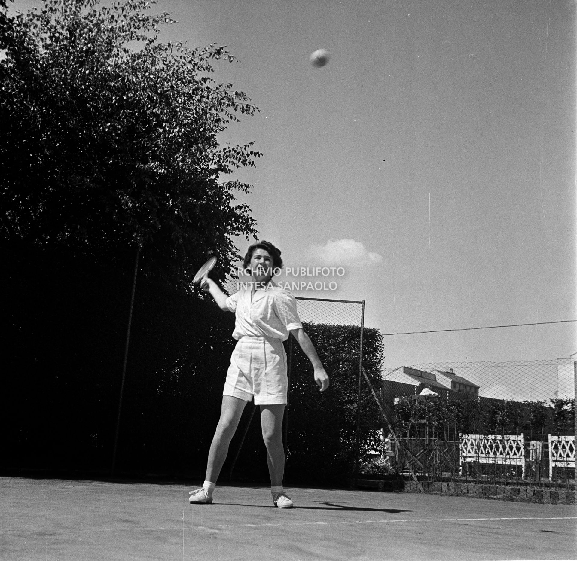 Una ragazza gioca a tennis in un campo all'aperto di Milano<br>73107