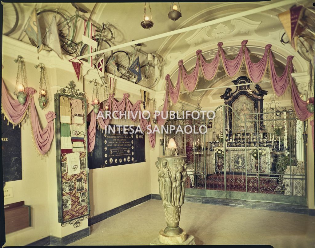 Interno del santuario della Madonna del Ghisallo a Mareggio con appese alle pareti biciclette, medaglie, gagliardetti e altri cimeli ciclistici