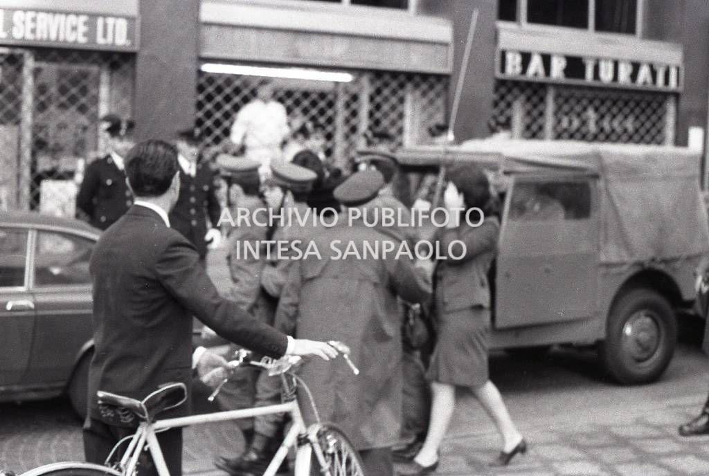 Passanti osservano un intervento delle forze dell'ordine in manifestazione<br>728362/5