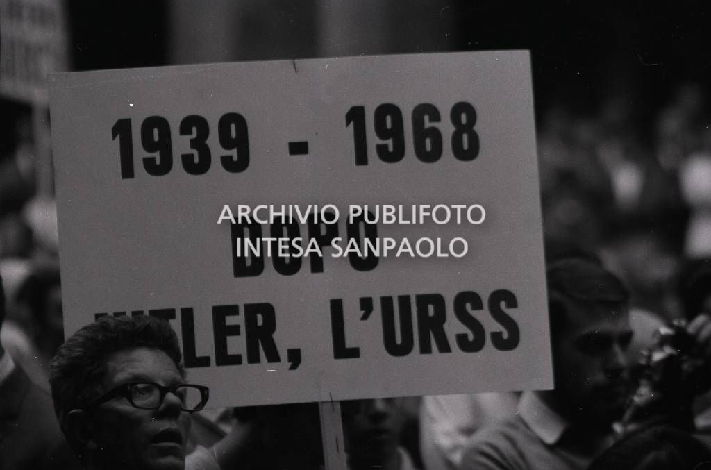 Manifestanti, in solidarietà della Cecoslovacchia occupata, ascoltano il discorso di Bettino Craxi in piazza Mercanti a Milano; in primo piano un cartello con la scritta: "1939-1968 Dopo Hitler l'URSS"