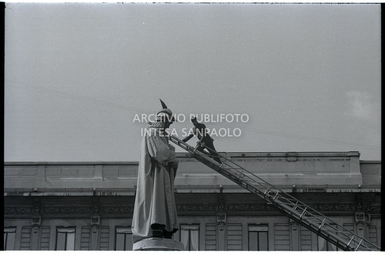 Decorazione del monumento a Leonardo da Vinci, in piazza della Scala a Milano, con il cappello da alpino, per mezzo di una scala telescopica<br>528562