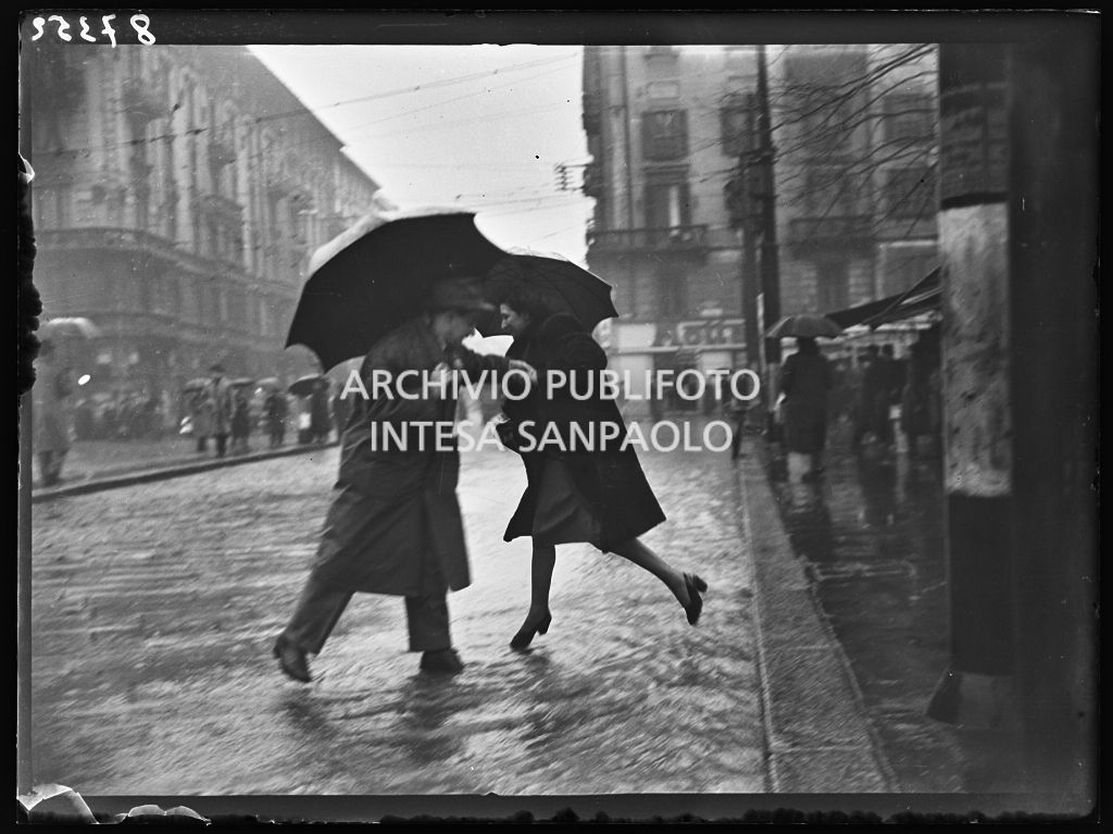 Due passanti attraversano piazzale Baracca, a Milano, allagato