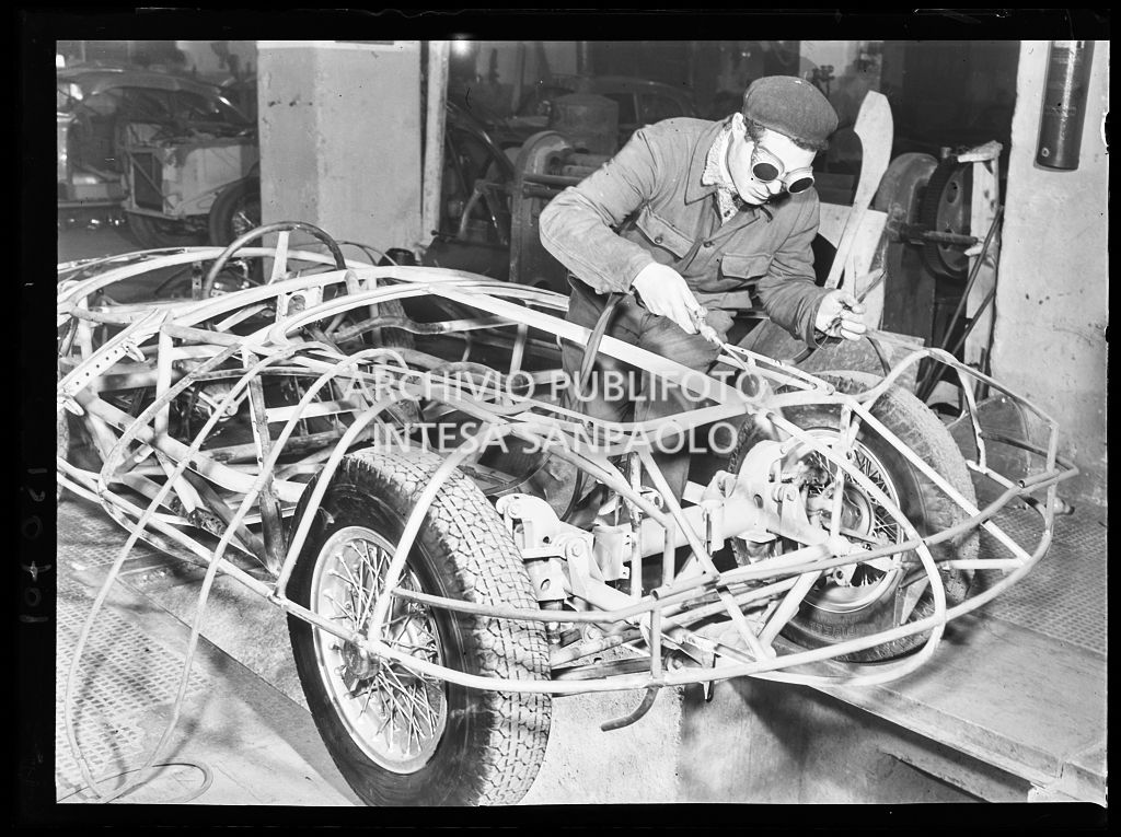 Un operaio in officina salda i tubolari del telaio del prototipo dell'Alfa Romeo C52 spider "Disco Volante"