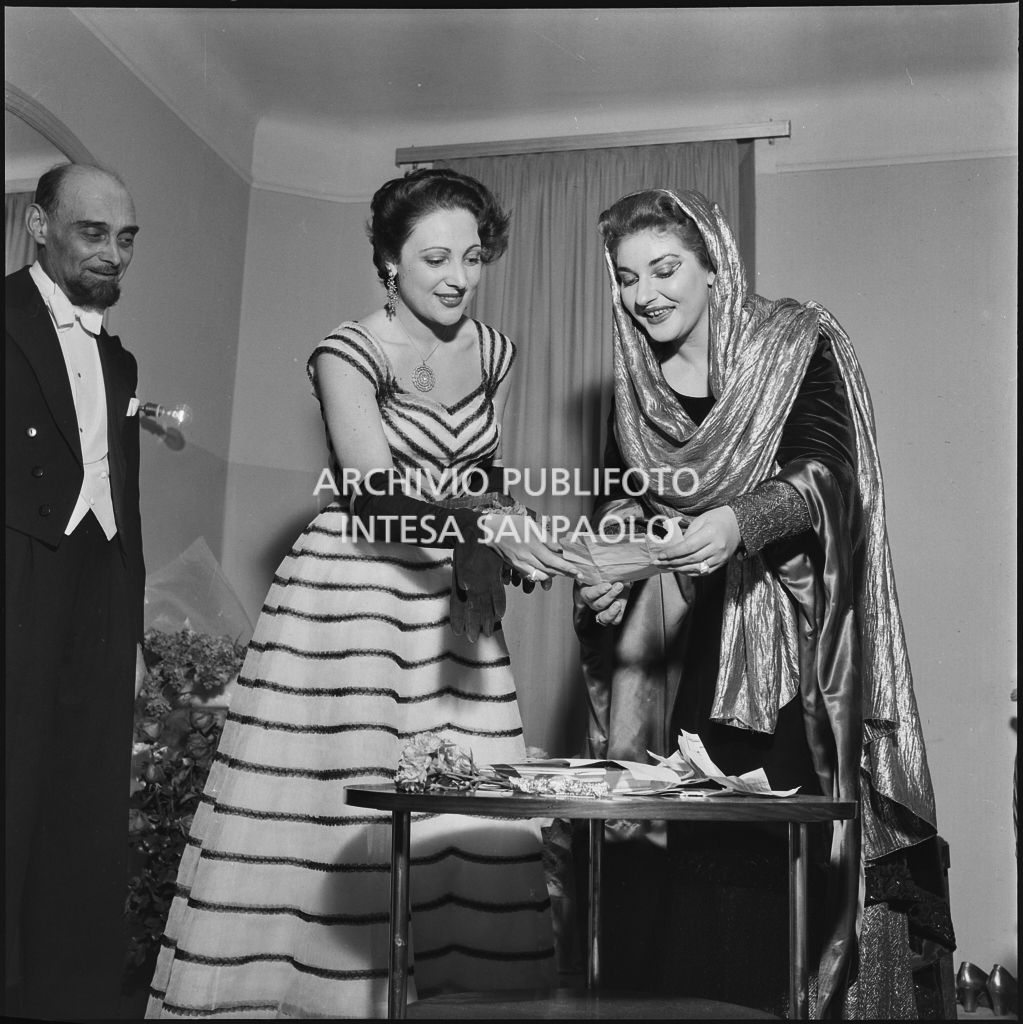 La soprano Maria Callas, in camerino, in costume di scena, insieme alla prima ballerina del Teatro alla Scala Luciana Novaro, la sera dell'inaugurazione della stagione lirica 1952-1953 con l'opera "Macbeth", di Giuseppe Verdi, diretta da Victor de Sabata, con la regia di Carl Ebert