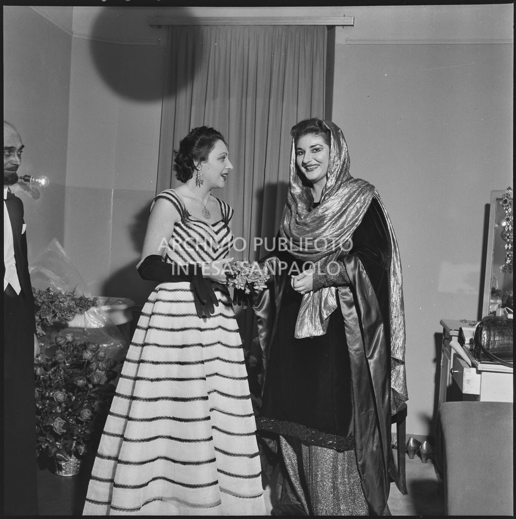 La soprano Maria Callas, in camerino, in costume di scena, insieme Luciana Novaro, prima ballerina del Teatro alla Scala, la sera dell'inaugurazione della stagione lirica 1952-1953 con l'opera "Macbeth", di Giuseppe Verdi, diretta da Victor de Sabata, con la regia di Carl Ebert