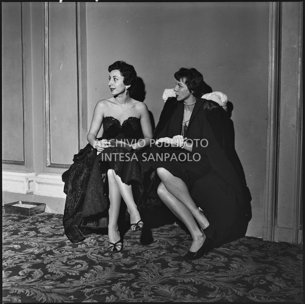 Alda Grimaldi e Maria Grazia Tiberto nel foyer del Teatro alla Scala in occasione della serata inaugurale della stagione lirica 1952-1953 con l'opera "Macbeth" di Giuseppe Verdi diretta da Victor de Sabata, con la regia di Carl Ebert