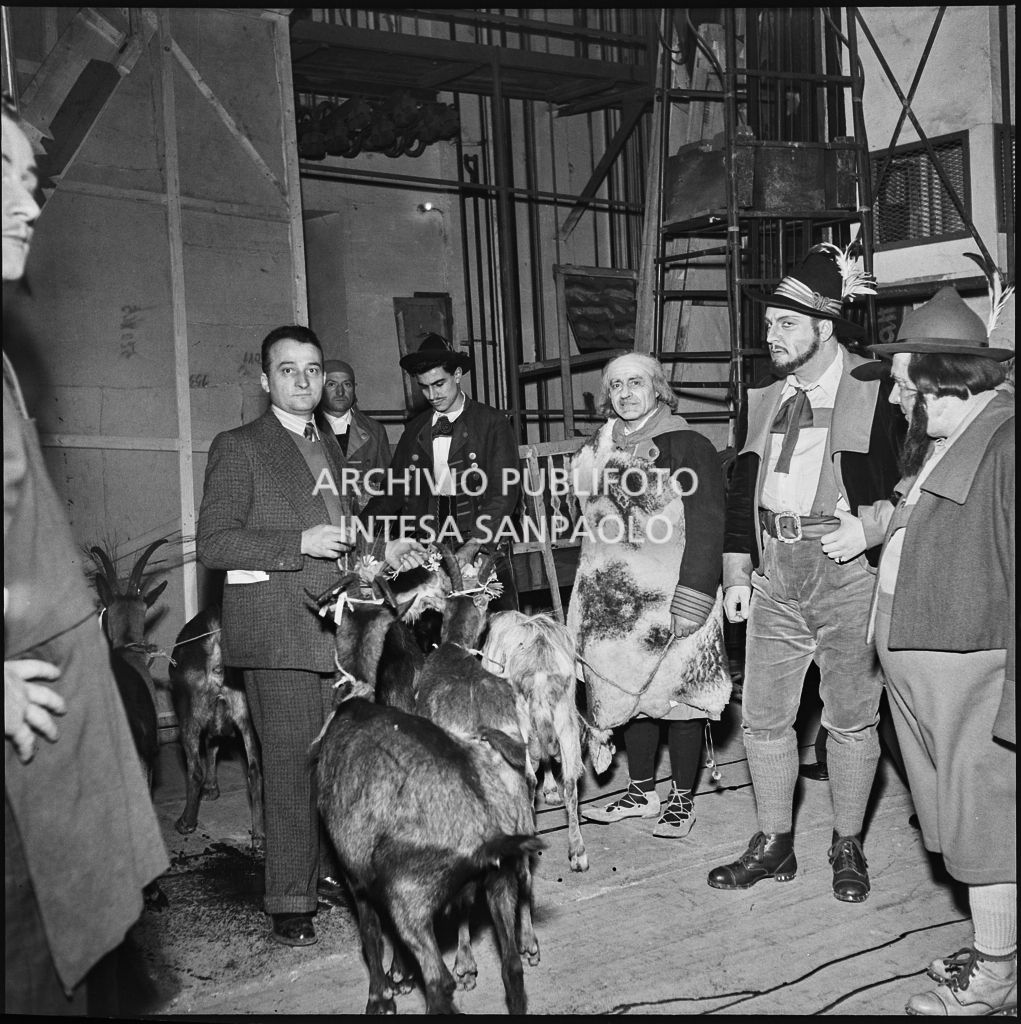 Il baritono Giangiacomo Guelfi con attori e capre dietro le quinte al Teatro alla Scala la sera dell'inaugurazione della stagione lirica 1953-1954 con l'opera "La Wally", di Alfredo Catalani, diretta da Carlo Maria Giulini, con la regia di Tatiana Pavlova