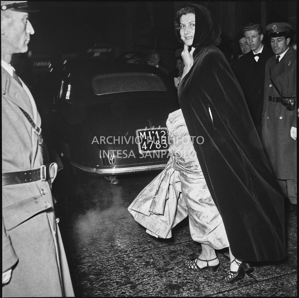 Una spettatrice sotto la pioggia in occasione della serata inaugurale della stagione lirica 1953-1954 del Teatro alla Scala con l'opera "La Wally", di Alfredo Catalani, diretta da Carlo Maria Giulini, con la regia di Tatiana Pavlova