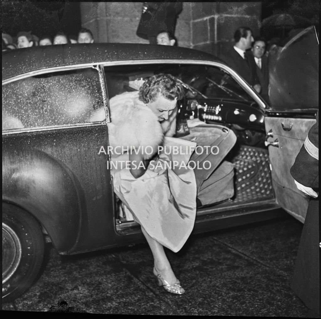 Una spettatrice scende dall'automobile nella galleria delle carrozze del Teatro alla Scala in occasione della serata inaugurale della stagione lirica 1953-1954 con l'opera "La Wally", di Alfredo Catalani, diretta da Carlo Maria Giulini, con la regia di Tatiana Pavlova