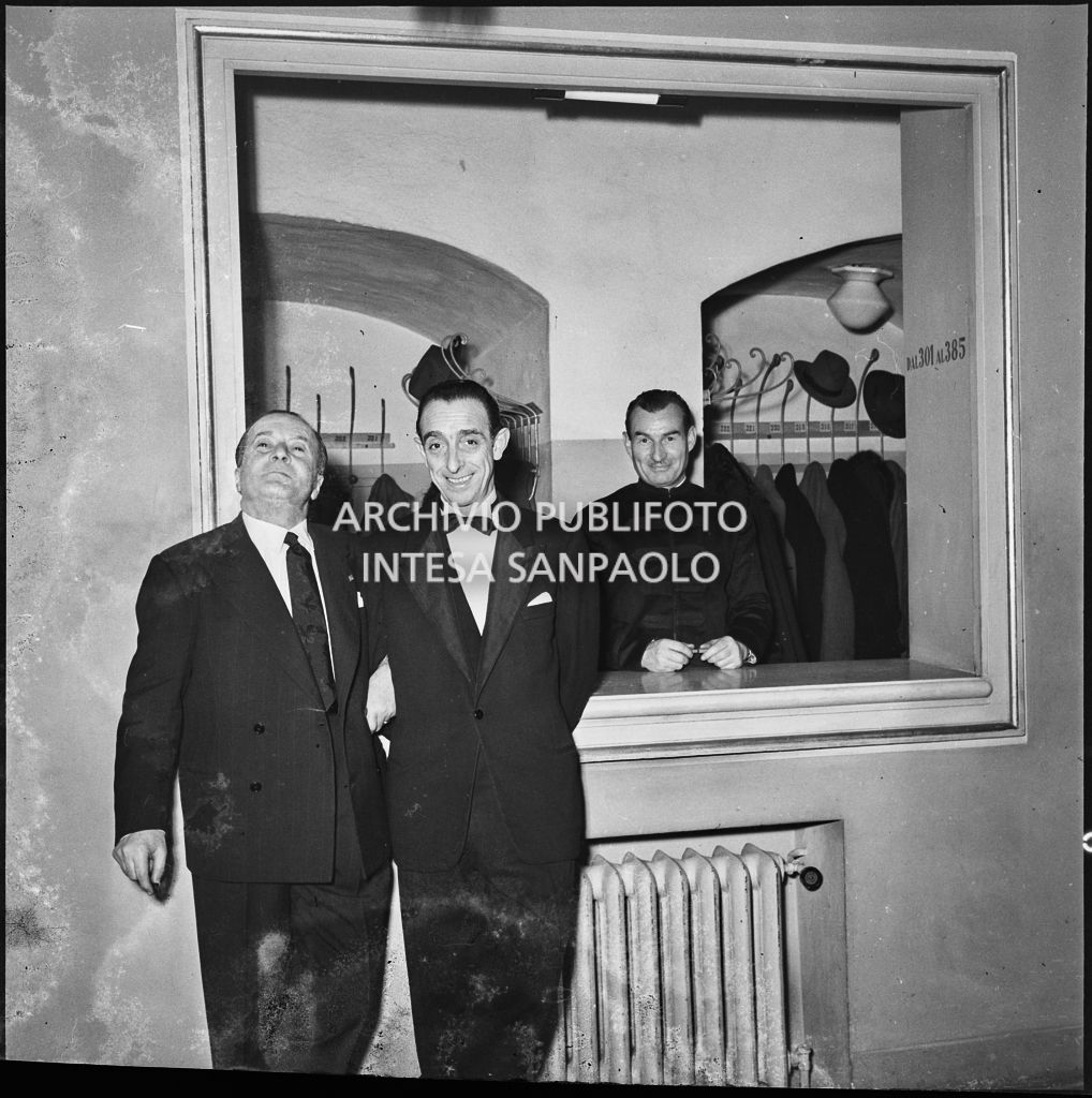 Due spettatori in posa davanti al guardaroba del Teatro alla Scala in occasione della serata inaugurale della stagione lirica 1953-1954 con l'opera "La Wally", di Alfredo Catalani, diretta da Carlo Maria Giulini, con la regia di Tatiana Pavlova