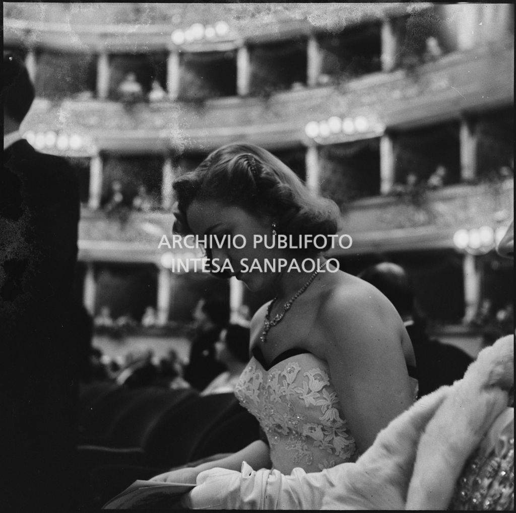 Una spettatrice seduta in platea al Teatro alla Scala in occasione della serata inaugurale della stagione lirica 1953-1954 con l'opera "La Wally", di Alfredo Catalani, diretta da Carlo Maria Giulini, con la regia di Tatiana Pavlova