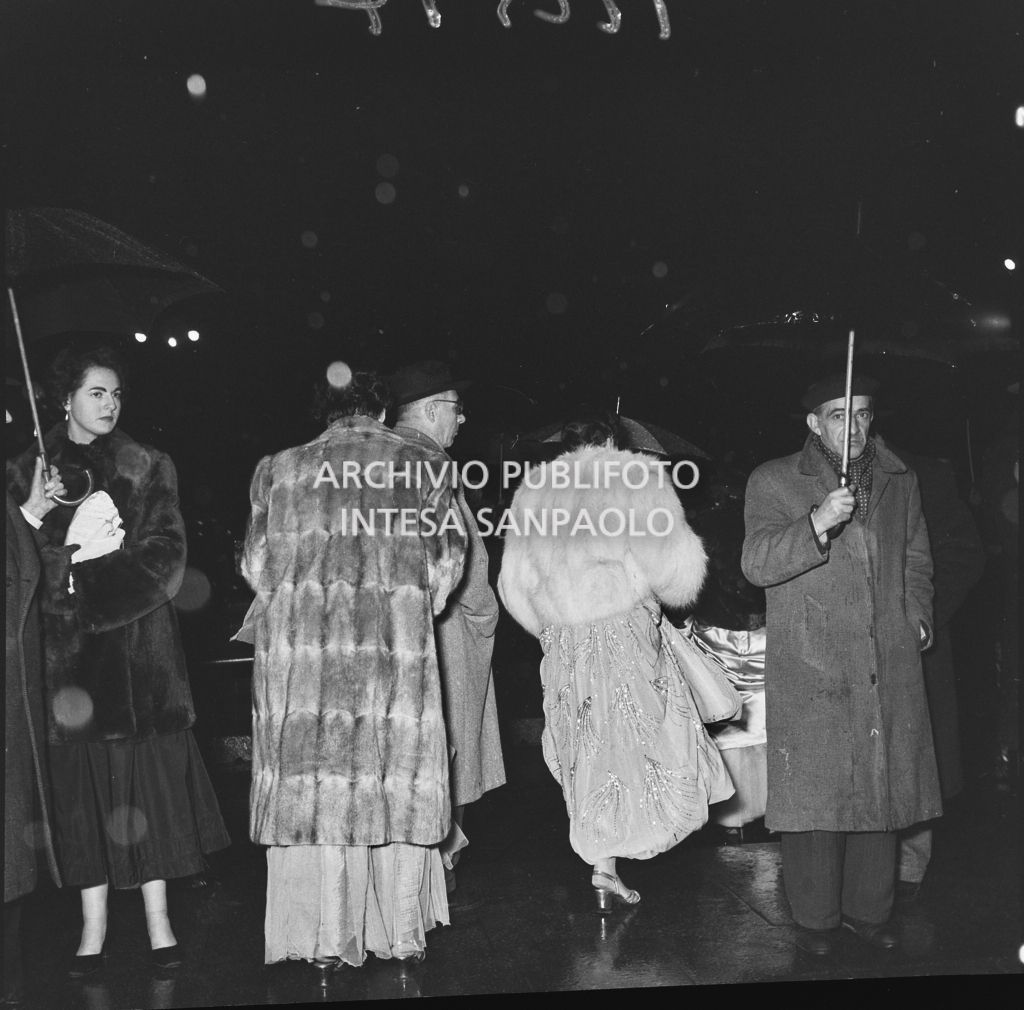 Alcuni spettatori all'esterno del Teatro alla Scala in occasione della serata inaugurale della stagione lirica 1953-1954 con l'opera "La Wally", di Alfredo Catalani, diretta da Carlo Maria Giulini, con la regia di Tatiana Pavlova
