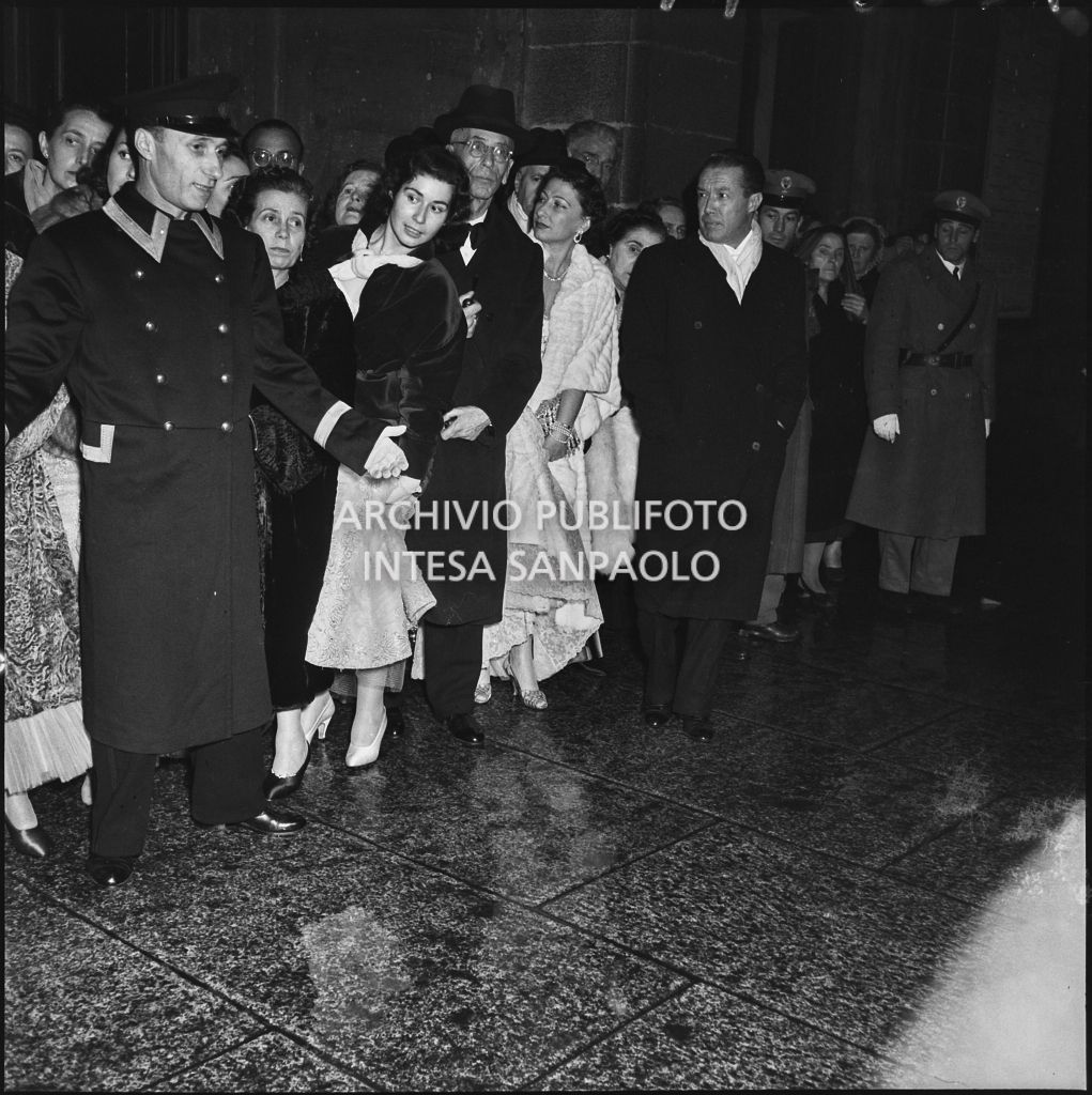Alcuni spettatori nella galleria delle carrozze del Teatro alla Scala, in attesa delle automobili, al termine della serata inaugurale della stagione lirica 1953-1954 con l'opera "La Wally", di Alfredo Catalani, diretta da Carlo Maria Giulini, con la regia di Tatiana Pavlova