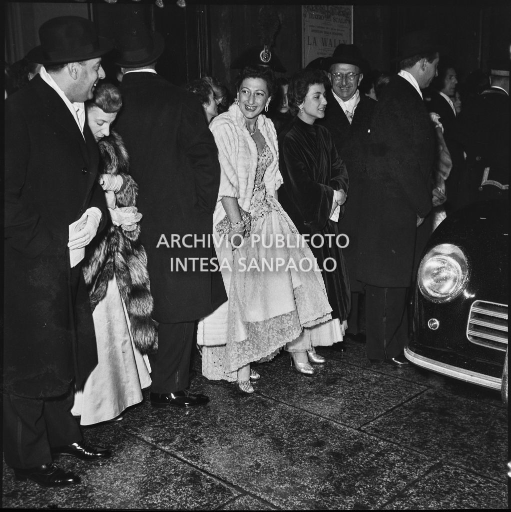 Alcuni spettatori nella galleria delle carrozze del Teatro alla Scala, in attesa delle automobili, al termine della serata inaugurale della stagione lirica 1953-1954 con l'opera "La Wally", di Alfredo Catalani, diretta da Carlo Maria Giulini, con la regia di Tatiana Pavlova