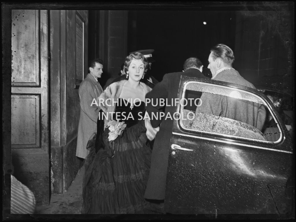 L'arrivo di una spettatrice al Teatro alla Scala la sera dell'inaugurazione della stagione lirica 1953-1954 con l'opera "La Wally", di Alfredo Catalani, diretta da Carlo Maria Giulini, con la regia di Tatiana Pavlova