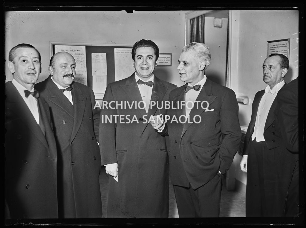 Il tenore Giuseppe Di Stefano (terzo da sinistra) in compagnia, tra gli altri, di Antonio Ghiringhelli, sovrintendente del Teatro alla Scala (quarto da sinistra), in occasione della serata inaugurale della stagione lirica 1953-1954 con l'opera "La Wally", di Alfredo Catalani, diretta da Carlo Maria Giulini, con la regia di Tatiana Pavlova